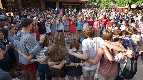 Students, faculty and family members gather during a candlelight vigil on campus Wednesday evening. The vigil was attended by hundreds. HYOSUB SHIN / HSHIN@AJC.COM
