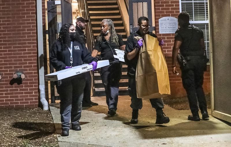 Investigators carry evidence from the scene of a triple shooting at the Berkeley Heights apartment building on Northside Drive. 