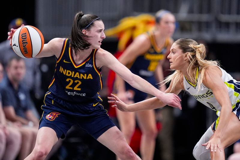 Dallas Wings guard Jacy Sheldon (4) defends Indiana Fever guard Caitlin Clark (22) in the first half of a WNBA basketball game in Indianapolis, Sunday, Sept. 15, 2024. (AP Photo/Michael Conroy)