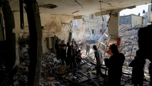 Palestinians examine the damage following an Israeli airstrike in the West Bank city of Tulkarem, which Palestinian health officials say killed 18 people and the Israeli military says took out a Hamas leader, on Friday, Oct. 4, 2024. (AP Photo/Nasser Nasser)