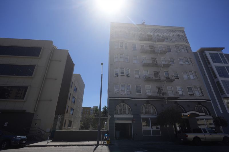 A worker cleans outside of a Five Keys transitional housing location in San Francisco, Monday, Aug. 26, 2024. (AP Photo/Jeff Chiu)