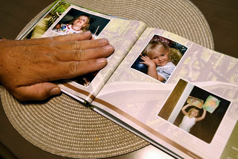 Robert Olds, uncle of Rikki Olds, who was fatally shot along with nine other people at a grocery store in Boulder, Colo., in 2021, looks through a memorial scrapbook in Lafayette, Colo., Tuesday, Aug. 27, 2024. (AP Photo/Thomas Peipert)