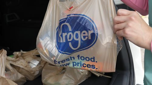 FILE - A customer moves purchases at a Kroger grocery store in Flowood, Miss., June 26, 2019. (AP Photo/Rogelio V. Solis, File)