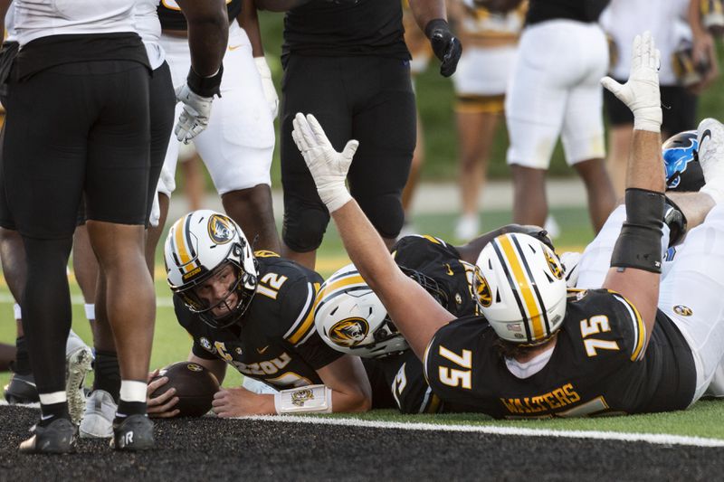 Missouri quarterback Brady Cook (12) looks up after scoring a touchdown as teammate Mitchell Walters (75) celebrates during the first half of an NCAA college football game against Buffalo, Saturday, Sept. 7, 2024, in Columbia, Mo. (AP Photo/L.G. Patterson)