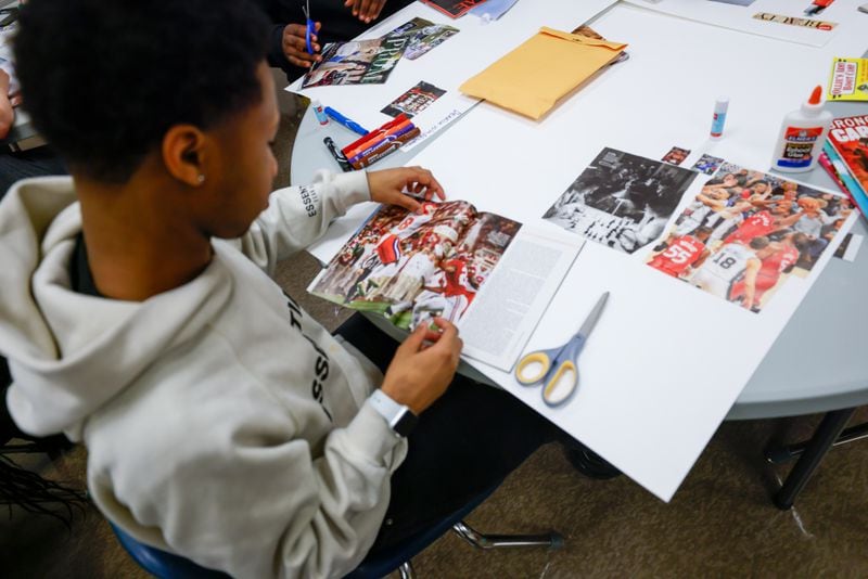 Redan High School student Montravious Favors works on his vision board during an end-of-year group project in Stone Mountain on Tuesday, May 14, 2024. The DeKalb County School District has placed one-on-one mentors at some schools this year to help improve students' attendance, behavior and academic performance. (Steve Schaefer / AJC)
