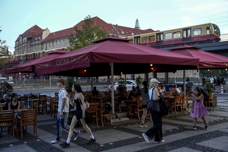 People eat doner in the outdoor area of a doner kebab restaurant in Berlin, Germany, Wednesday, Sept. 18, 2024. (AP Photo/Ebrahim Noroozi)