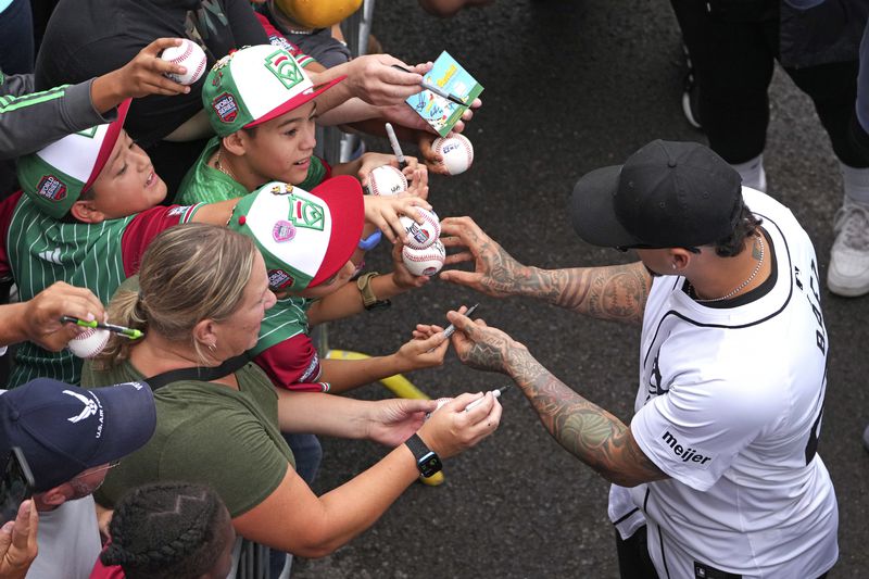 Detroit Tigers' Javier Báez, right, signs autographs as he arrives for a team visit to the Little League World Series tournament in South Williamsport, Pa., Sunday, Aug. 18, 2024. The Tigers will be playing the New York Yankees in the Little League Classic at Bowman Stadium in Williamsport, Pa., on Sunday Night Baseball. (AP Photo/Gene J. Puskar)