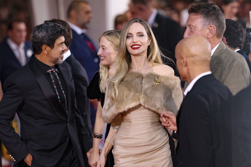 Pierfrancesco Favino, left, and Angelina Jolie pose for photographers upon arrival for the premiere of the film 'Maria' during the 81st edition of the Venice Film Festival in Venice, Italy, on Thursday, Aug. 29, 2024. (Photo by Vianney Le Caer/Invision/AP)