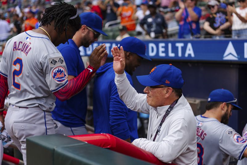 New York Mets owner, Steve Cohen, right, high fives Luisangel Acuña in the dugout after winning the game in the ninth inning of a baseball game against the Atlanta Braves, Monday, Sept. 30, 2024, in Atlanta. (AP Photo/Jason Allen)