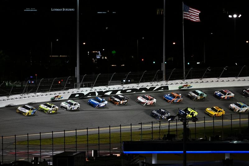 Michael McDowell (34) leads drivers through Turn 4 during a NASCAR Cup Series auto race at Daytona International Speedway, Saturday, Aug. 24, 2024, in Daytona Beach, Fla. (AP Photo/Phelan M. Ebenhack)