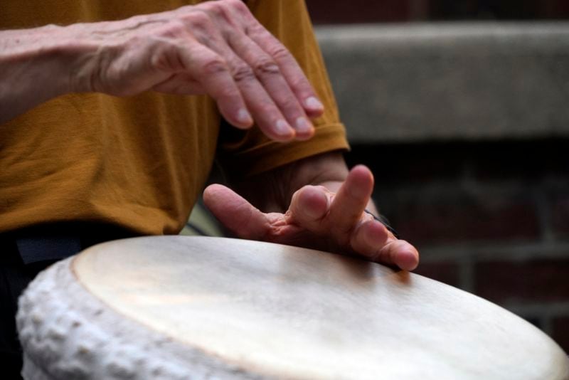 A man plays music at a drum circle Friday, Oct. 4, 2024 in Asheville, N.C., a week after Hurricane Helene upended lives across the Southeast. (AP Photo/Brittany Peterson)