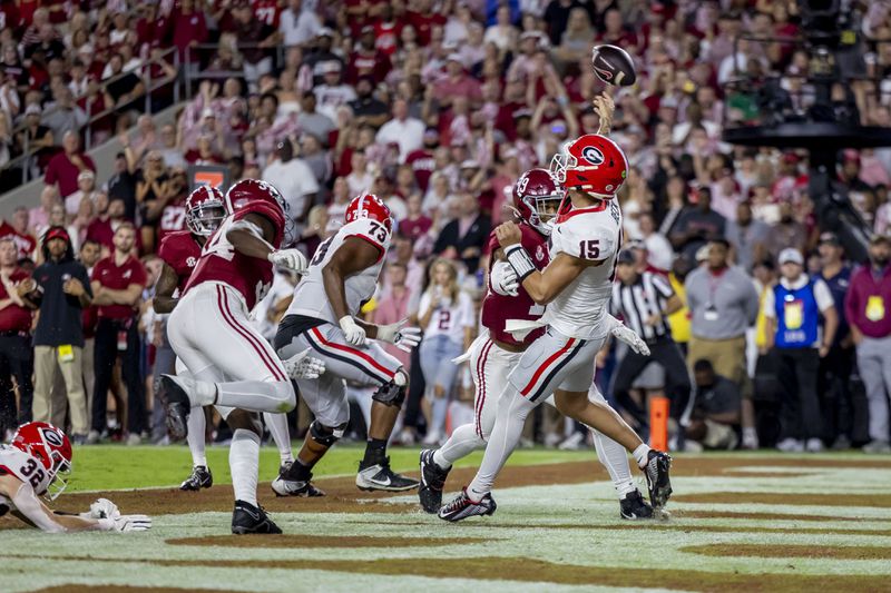 Georgia quarterback Carson Beck (15) throws from the end zone under pressure from Alabama linebackers Que Robinson and Keanu Koht during the first half of an NCAA college football game, Saturday, Sept. 28, 2024, in Tuscaloosa, Ala. (AP Photo/Vasha Hunt)