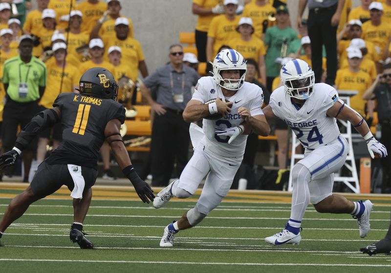 Air Force quarterback Josh Busha, center, gets help from teammate Aiden Calvert, right, while being pressured by Baylor linebacker Keaton Thomas during the first half of an NCAA college football game, Saturday, Sept. 14, 2024, in Waco, Texas. (Rod Aydelotte/Waco Tribune-Herald via AP)