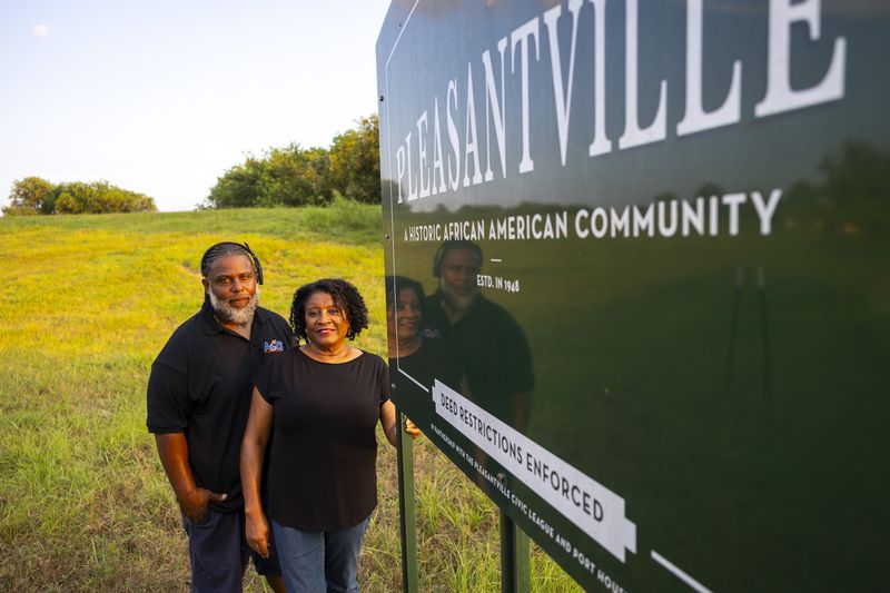 Ricky Johnson and Bridgette Murray, who work to raise awareness of issues caused by pollution, pose in front of a sign for the Pleasantville area of Houston, Saturday, Aug. 17, 2024. (AP Photo/Annie Mulligan)