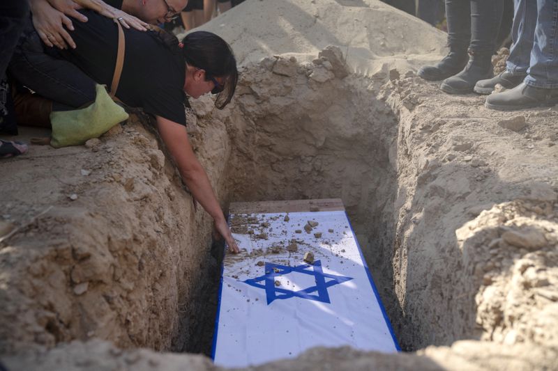 Rimon Buchshtab mourns during the funeral of her husband Yagev Buchshtab at a cemetery of the Kibbutz Nirim, southern Israel, Wednesday, Aug. 21, 2024. Buchshtab's body was one of six bodies of hostages, taken in Hamas' Oct. 7 attack, recovered by Israel's military during an operation in the Gaza Strip. (AP Photo/Leo Correa)