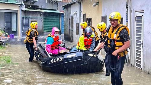 In this photo released by the Taiwan Ministry of National Defense, rescue workers evacuate residents trapped by flood waters in the aftermath of Typhoon Gaemi in Chiayi county in southwestern Taiwan, Friday, July 26, 2024. (Taiwan Ministry of National Defense via AP)