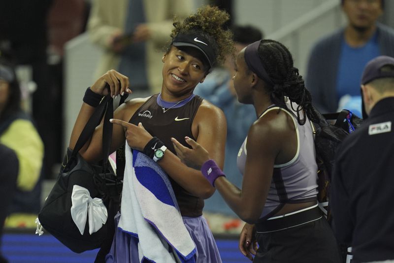 Coco Gauff of the United States speaks to Naomi Osaka of Japan after Osaka retired due to a injury in a women's singles match for the China Open tennis tournament held at the National Tennis Center in Beijing, Tuesday, Oct. 1, 2024. (AP Photo/Ng Han Guan)