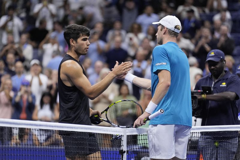 Botic van De Zandschulp, right, of the Netherlands, greets Carlos Alcaraz, of Spain, during the second round of the U.S. Open tennis championships, Thursday, Aug. 29, 2024, in New York. (AP Photo/Matt Rourke)