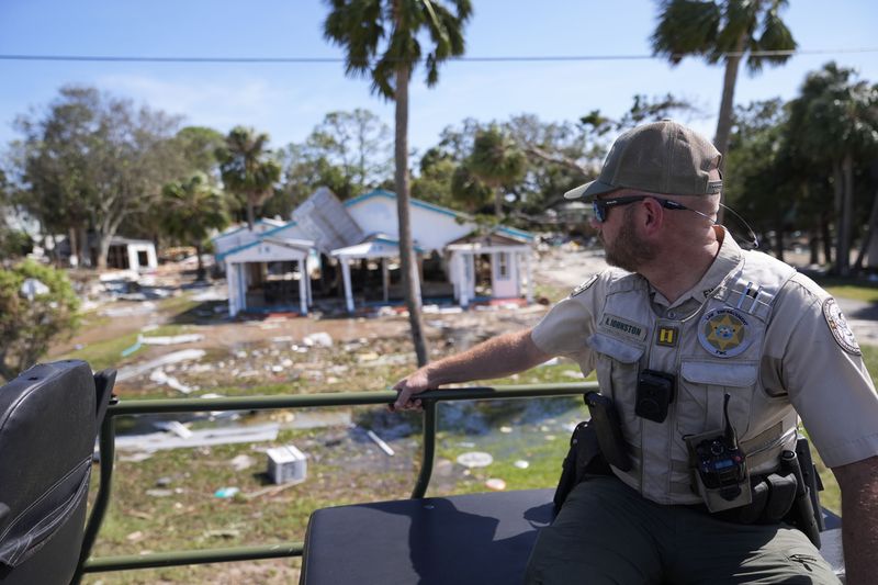 Capt. BJ Johnston, a law enforcement officer from the Florida Fish Wildlife and Conservation Commission, surveys destruction from a high water buggy in the aftermath of Hurricane Helene, in Cedar Key, Fla., Friday, Sept. 27, 2024. (AP Photo/Gerald Herbert)