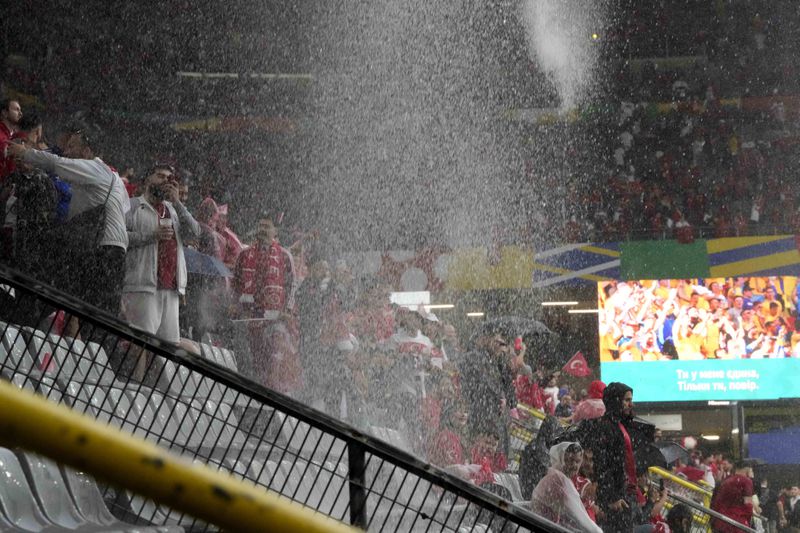 Heavy rain falls as fans await the start of a Group F match between Turkey and Georgia at the Euro 2024 soccer tournament in Dortmund, Germany, Tuesday, June 18, 2024. (AP Photo/Martin Meissner)