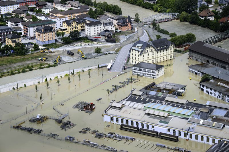 A view of the Rhone river, at right, and the Navizence river, following the storms that caused major flooding, in Chippis, Switzerland, Sunday, June 30, 2024. The Rhone river burst its banks in several areas of Valais canton, flooding a highway and a railway line. (Jean-Christophe Bott/Keystone via AP)