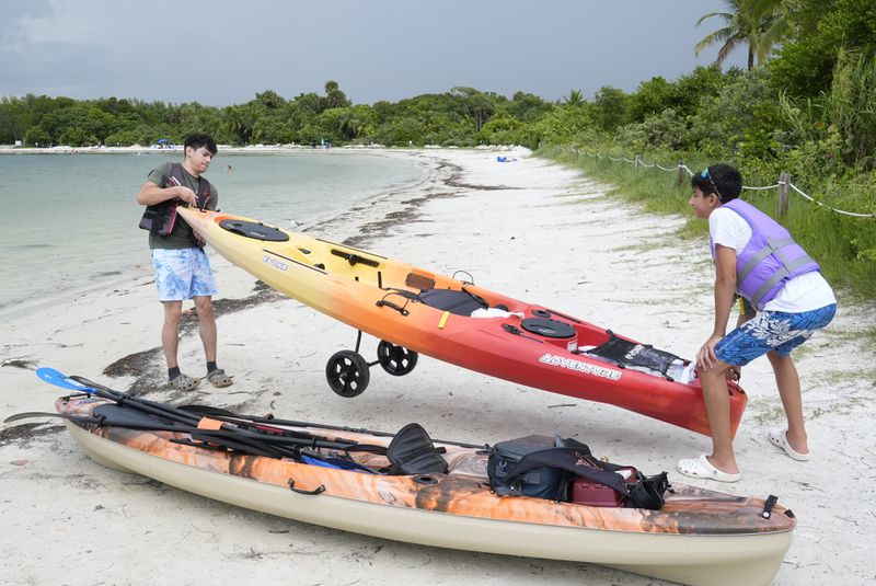 Joshua Gross, right, and his brother Joseph, of Miami, prepare to launch their kayaks off the beach at Oleta River State Park, Thursday, Aug. 22, 2024, in North Miami Beach, Fla. (AP Photo/Marta Lavandier)