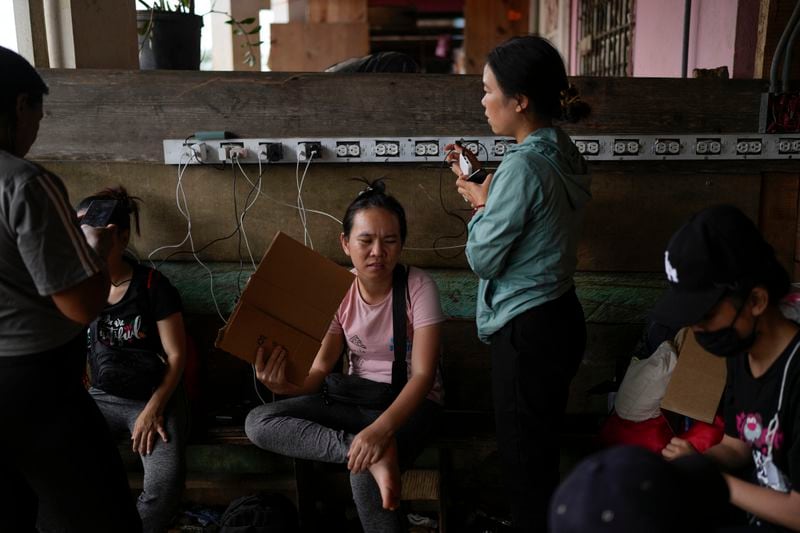 Migrants from Vietnam charge their phones at a camp for those who walk across the Darien Gap in hope of reaching the U.S., in Lajas Blancas, Panama, Thursday, Sept. 26, 2024. (AP Photo/Matias Delacroix)