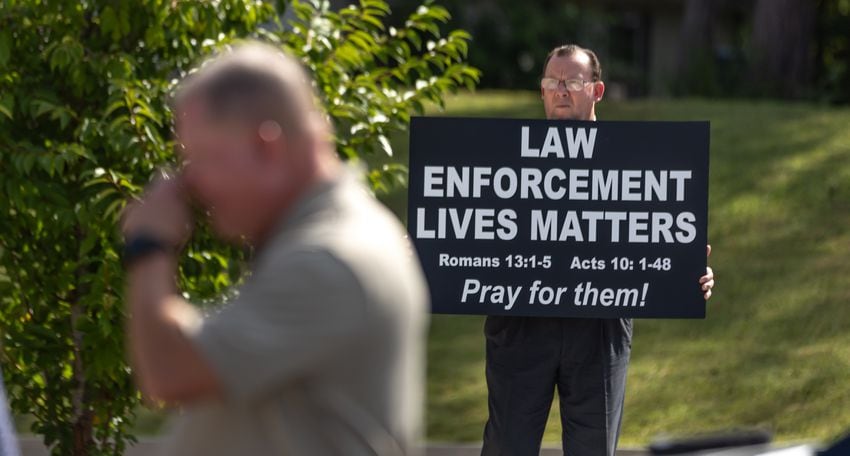 Street preacher Douglas Pitts holds a sign of prayer support on Monday, Aug. 19, 2024, in front of Paulding County Sheriff's office. Deputy Brandon Cunningham was the first Paulding deputy killed in the line of duty.  (John Spink/AJC)