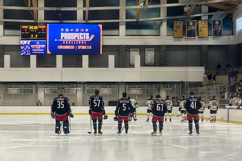 Columbus Blue Jackets line up at their blue line for the national anthem with Boston Bruins before the Sabres Prospects Challenge hockey game in Buffalo, N.Y., Saturday, Sept. 14, 2024. (AP Photo/John Wawrow)