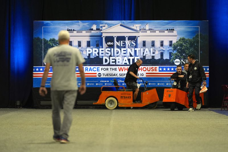 Workers pass signage at the media filing center ahead of the presidential debate in Philadelphia.