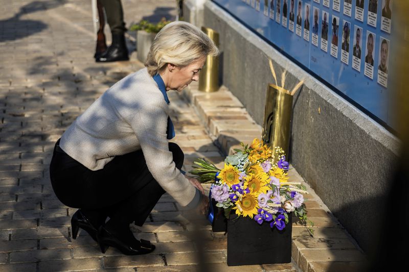 President of the European Commission Ursula von der Leyen places a bouquet of flowers at a wall commemorating the fallen Ukrainian soldiers in the war with Russia, in Kyiv, Ukraine, Friday, Sept. 20, 2024. (Christoph Soeder, Pool via AP)