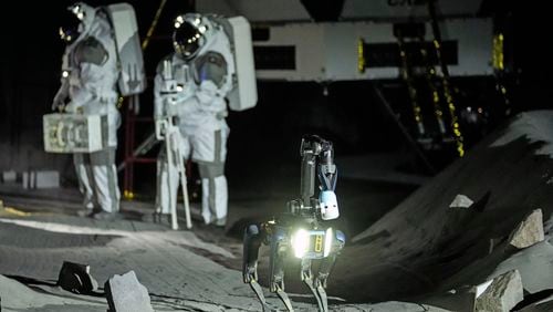 Astronauts Thomas Pesquet of France and Matthias Maurer of Germany and their canine-like robot demonstrate their training in lunar surface simulating conditions for future moon missions, like the Artemis lunar exploration program led by NASA, at the opening of the new LUNA facility at the European Astronaut Center in Cologne, Germany, Wednesday, Sept. 25, 2024. (AP Photo/Martin Meissner)