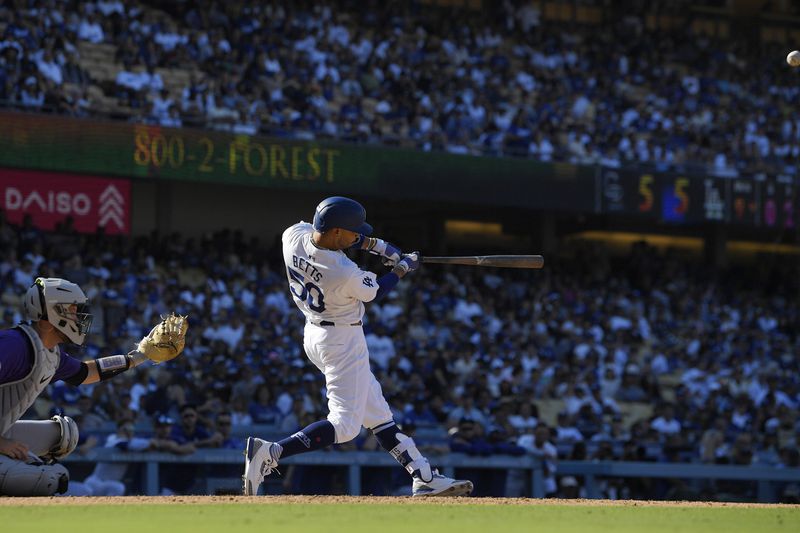 Los Angeles Dodgers' Mookie Betts, right, hits a walk-off home run as Colorado Rockies catcher Jacob Stallings watches during the ninth inning of a baseball game, Sunday, Sept. 22, 2024, in Los Angeles. (AP Photo/Mark J. Terrill)