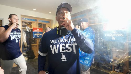 Los Angeles Dodgers manager Dave Roberts celebrates with others after the Dodgers defeated the San Diego Padres 7-2 in a baseball game to clinch the National League West division Thursday, Sept. 26, 2024, in Los Angeles. (AP Photo/Ashley Landis)