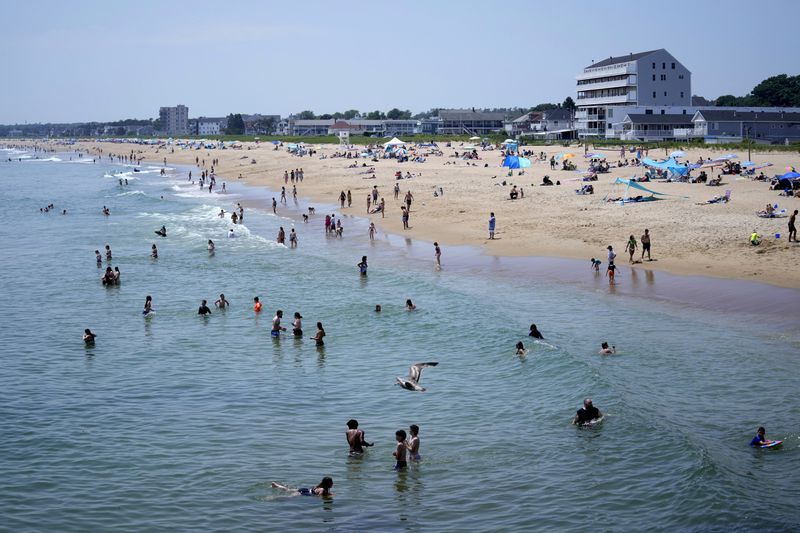 The cool waters of the Atlantic Ocean attract a crowd to Old Orchard Beach, Maine, Tuesday, June 18, 2024. The heat wave that has been hitting much of the United States is now moving into the Northeast. (AP Photo/Robert F. Bukaty)
