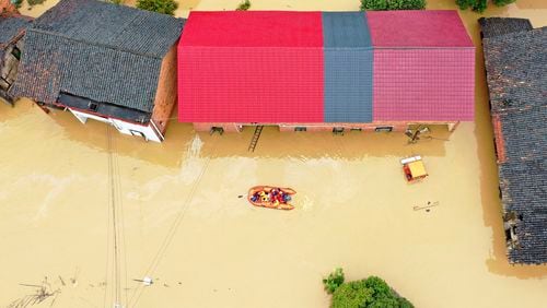 Rescuers use a dinghy boat to evacuate villagers trapped by floodwaters in Jingtang village, Zixing city, in southern China's Hunan province Sunday, July 28, 2024. (Chinatopix Via AP)