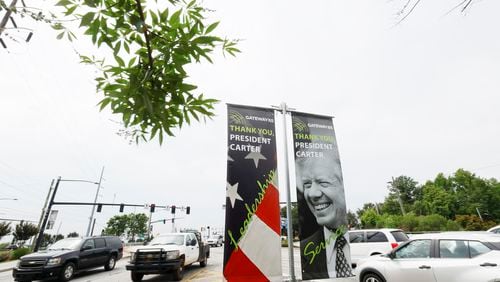 A series of banners pay tribute to President Jimmy Carter at the exit on Jimmy Carter Boulevard on Tuesday, May 23, 2023. The initiative, conceived by Gateway85 CID, showcases the enduring legacy of President Jimmy Carter. Miguel Martinez /miguel.martinezjimenez@ajc.com