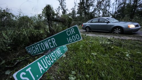 Vehicles move slowly around trees that have fallen after of Hurricane Helene moved through the area, Friday, Sept. 27, 2024, in Valdosta, Ga. (AP Photo/Mike Stewart)