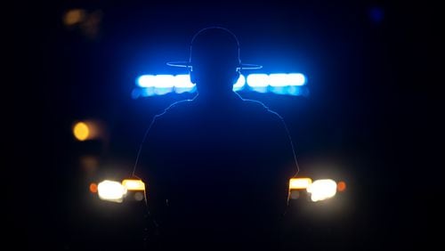 A state trooper watches pro-Palestinian protesters rally April 25 at Emory University in Atlanta. (Arvin Temkar/Atlanta Journal-Constitution)