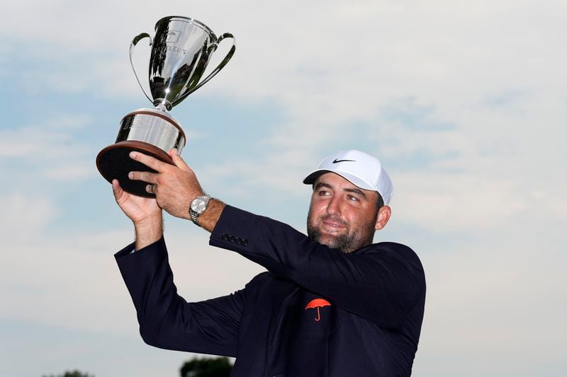Scottie Scheffler hold sup his trophy after winning the Travelers Championship golf tournament at TPC River Highlands, Sunday, June 23, 2024, in Cromwell, Conn. (AP Photo/Seth Wenig)