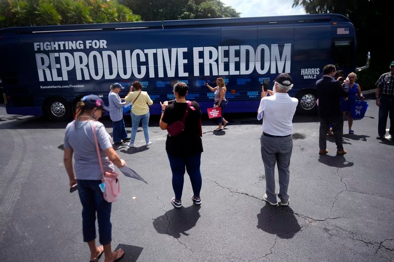 People take pictures of the bus at a kickoff event in Florida for the "Reproductive Freedom Bus Tour" by the campaign of Vice President Kamala Harris, Democratic presidential nominee.