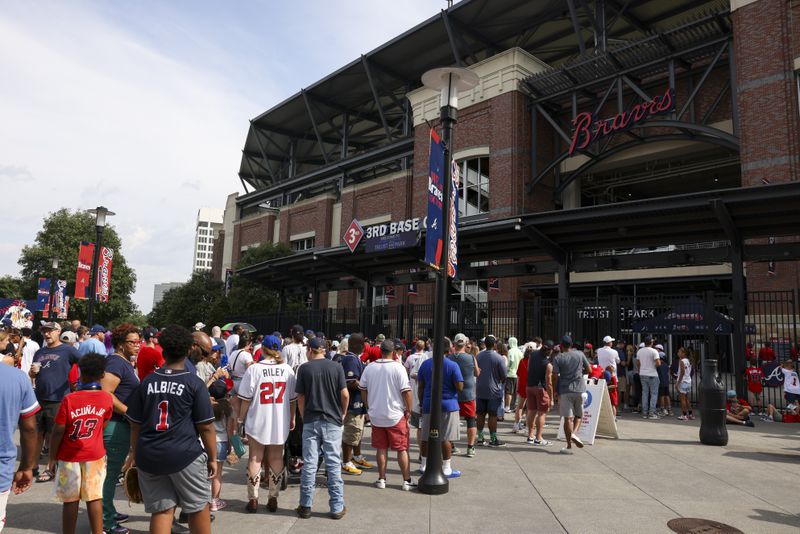 Atlanta Braves fans wait in line outside of the third base gate at Truist Park, Tuesday, August 6, 2024, in Atlanta. Fans waited in line for the gates to open to receive an OutKast bobblehead, featuring duo Big Boi and Andre 3000. The first 15,000 fans received this bobblehead. (Jason Getz / AJC)
