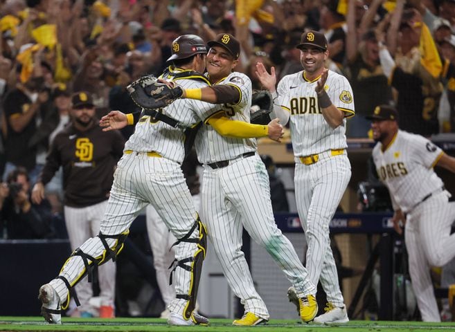 San Diego Padres catcher Kyle Higashioka(20) embraces teammates after fielding the last out from Atlanta Braves’ Travis d'Arnaud to end National League Division Series Wild Card Game Two at Petco Park in San Diego on Wednesday, Oct. 2, 2024. Atlanta lost 5-4 allowing the Padres to advance to the Division Series and face the Los Angeles Dodgers.   (Jason Getz / Jason.Getz@ajc.com)