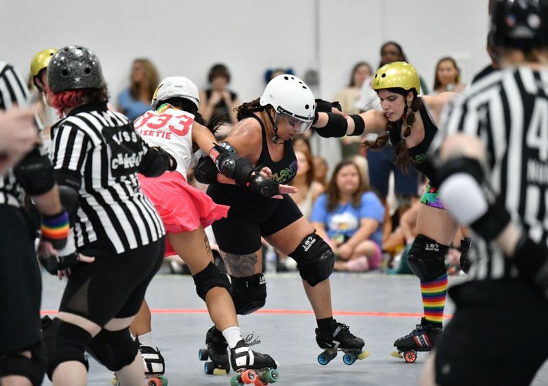 Donita Green (center), a.k.a. Blaxyl Rose, challenges during Atlanta Roller Derby game at Agnes Scott College’s Woodruff Athletic Complex, Saturday, June 8, 2024, in Decatur. (Hyosub Shin / AJC)