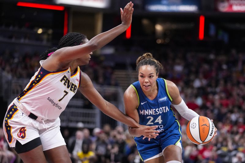 Minnesota Lynx forward Napheesa Collier (24) dribbles toward Indiana Fever forward Aliyah Boston (7) during the first half of a WNBA basketball game in Indianapolis, Friday, Sept. 6, 2024. (AP Photo/Michael Conroy)