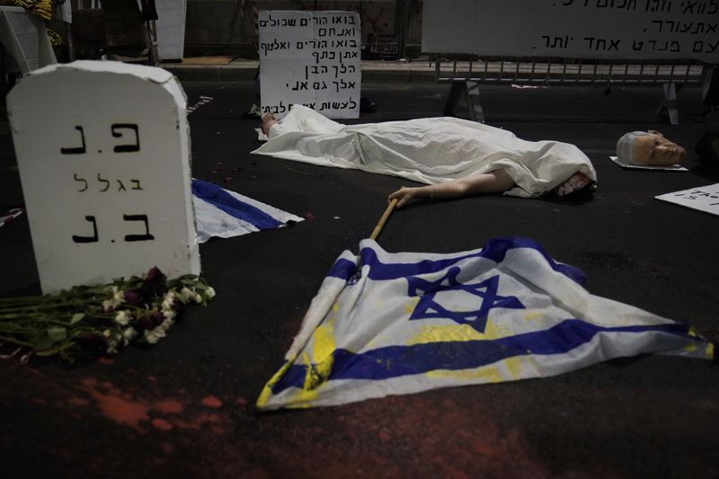 A demonstrator takes part in a performance during a protest against Prime Minister Benjamin Netanyahu's government and call for the release of hostages held in the Gaza Strip by the Hamas militant group, in Tel Aviv, Israel, Saturday, Sept. 14, 2024. (AP Photo/Mahmoud Illean)