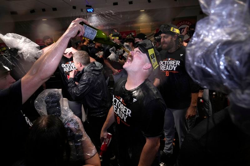 Detroit Tigers catcher Jake Rogers, center, celebrates with the team in the clubhouse after the their 5-2 win against the Houston Astros in Game 2 of an AL Wild Card Series baseball game Wednesday, Oct. 2, 2024, in Houston. (AP Photo/Kevin M. Cox)