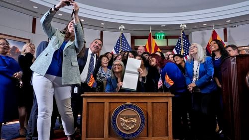 FILE - Arizona Rep. Stephanie Stahl Hamilton takes a selfie with Arizona Gov. Katie Hobbs after Hobbs signed the repeal of the Civil War-era near-total abortion ban on May 2, 2024, at the state Capitol in Phoenix. (AP Photo/Matt York, File)