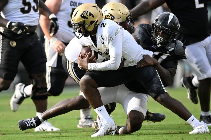 Colorado quarterback Shedeur Sanders (2) is sacked by Central Florida defensive end Nyjalik Kelly, right, during the first half of an NCAA college football game, Saturday, Sept. 28, 2024, in Orlando, Fla. (AP Photo/Phelan M. Ebenhack)