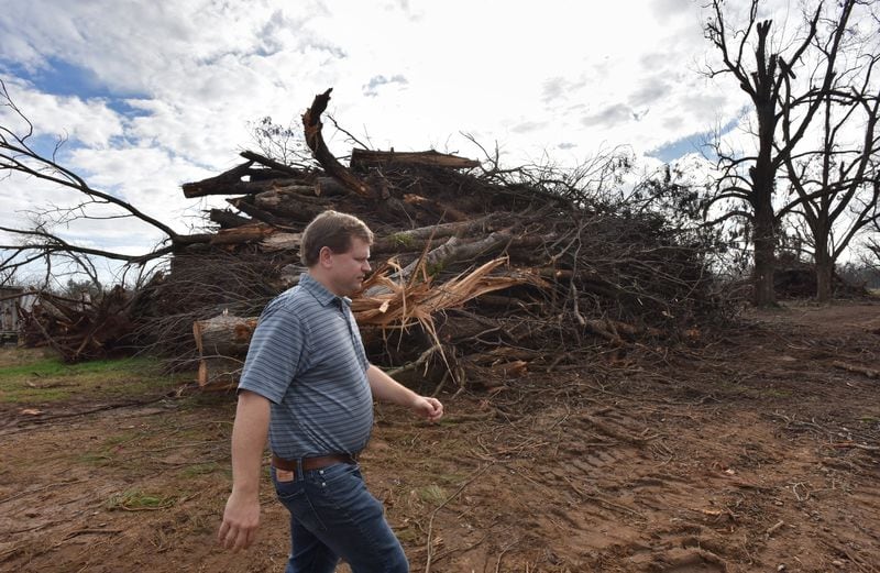 South Georgia pecan farmer Trey Pippin walks past a pile of dead pecan trees at his farm in Albany in 2019. South Georgia farmers will get some federal disaster relief aid for the estimated $2.5 billion in losses from Hurricane Michael. HYOSUB SHIN / HSHIN@AJC.COM